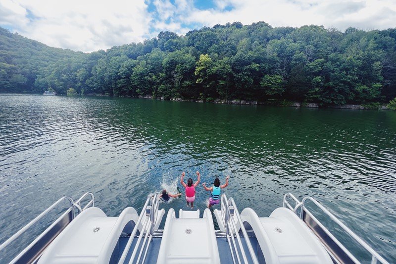 3 kids sliding down the triple slide into the water