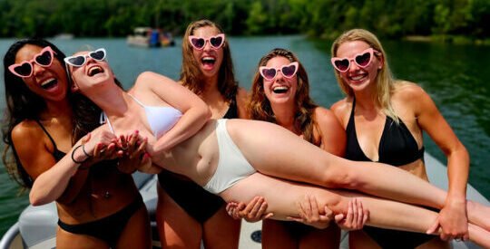 bride being held up by her bridesmaids during her bachelorette party cruise in nashville tn