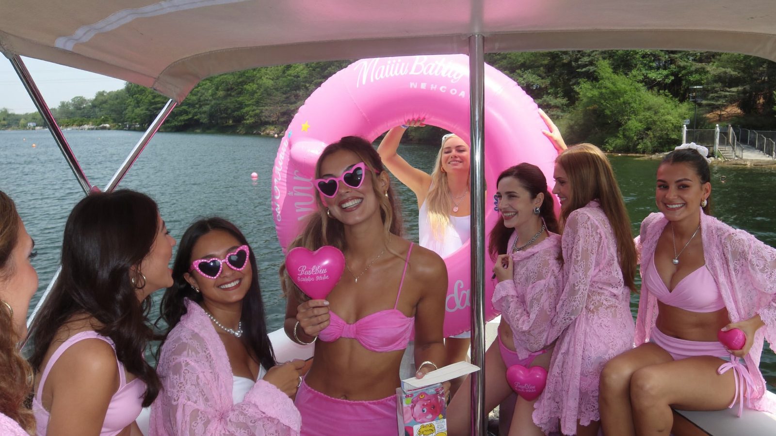 Pink-everything bachelorette group with bride in white on a Nashville pontoon - Malibu Barbie theme